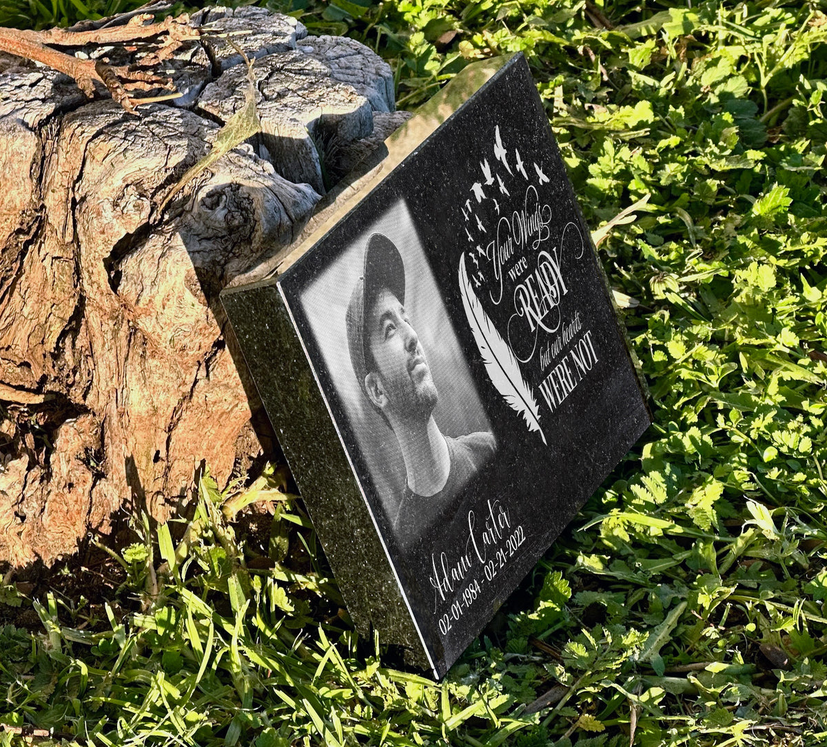 Angled view of a black granite photo plaque with a feather, birds and Your Wings Were Ready wording