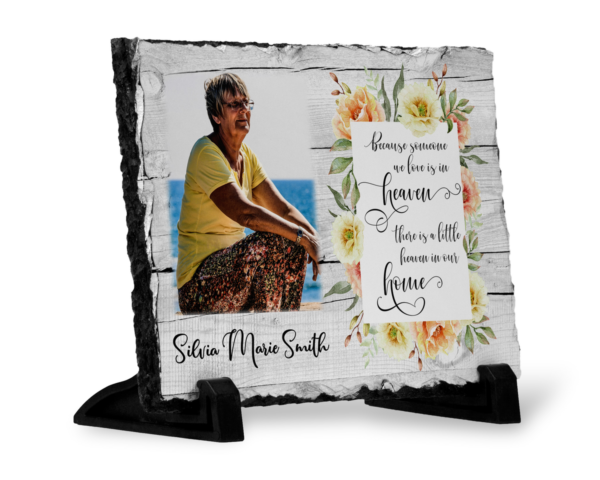 Angled view of a floral memorial photo slate with a woman’s portrait, Heaven tribute, whitewashed-wood print and black stands