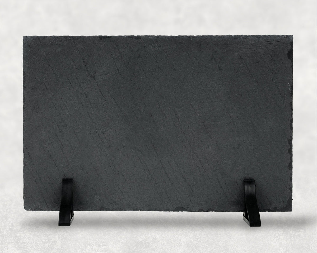 Unprinted reverse side of a rectangular natural slate plaque supported by two black display stands